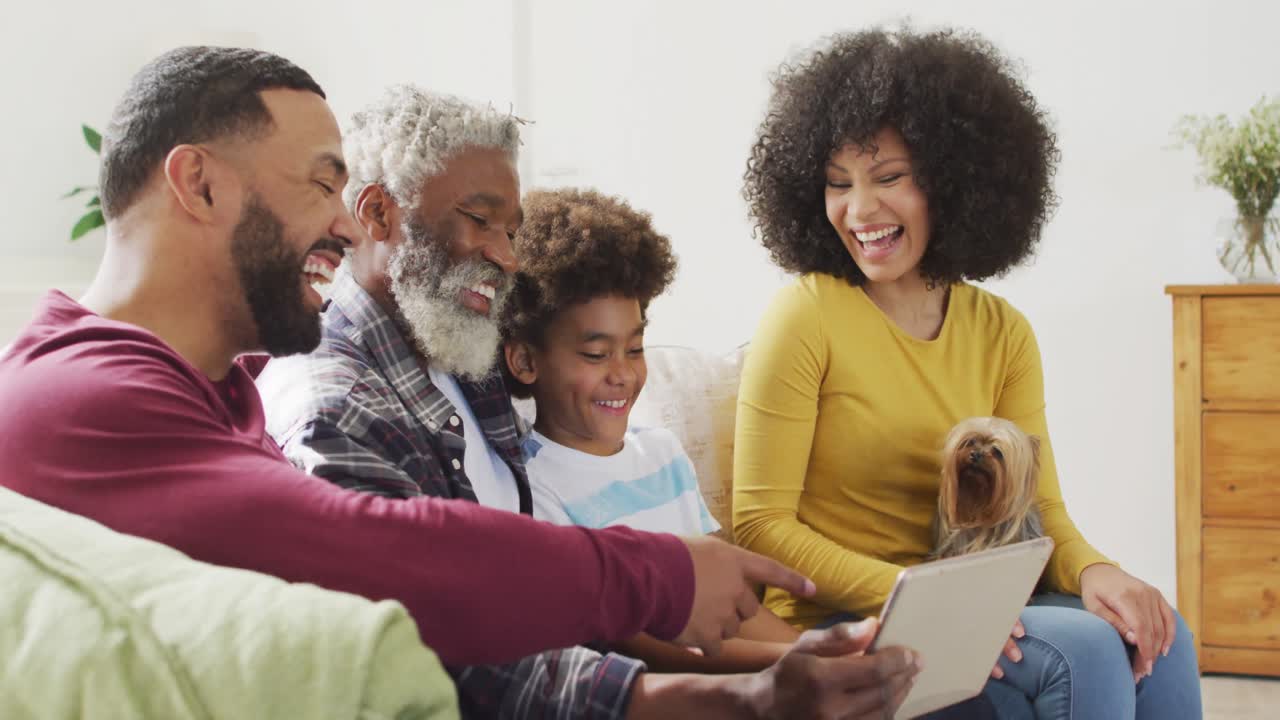 Multi-generation family laughing while using digital tablet at home