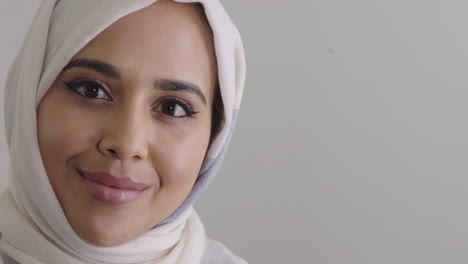 happy young muslim woman smiling enjoying successful lifestyle wearing traditional hijab headscarf on blank background copy space close up