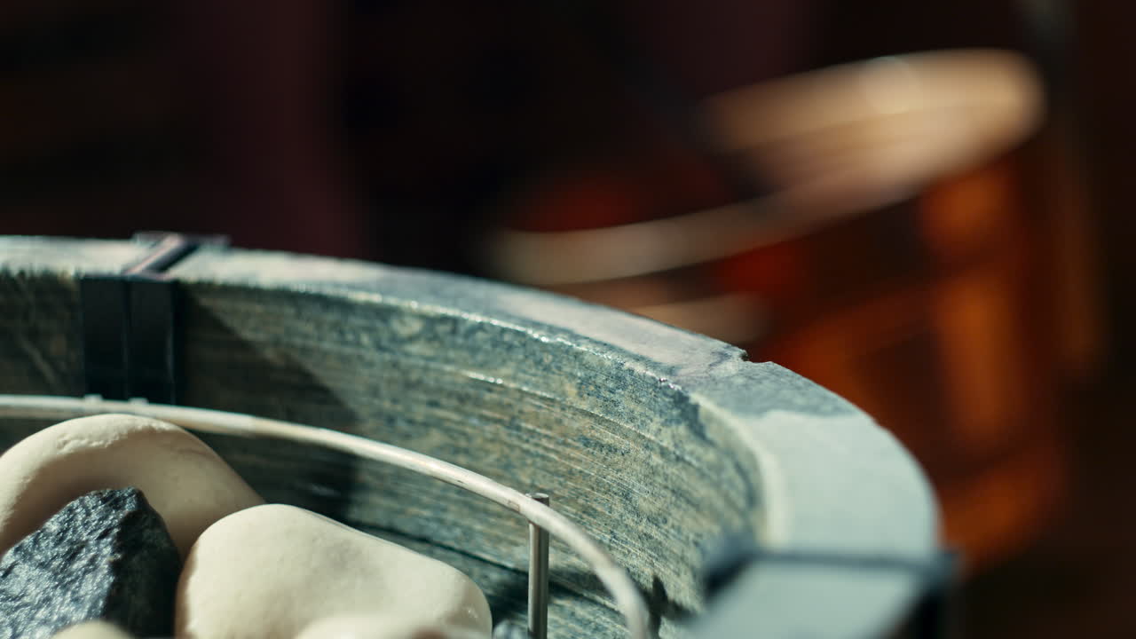 arrojando agua sobre piedras de sauna calientes en la estufa de sauna, usando una cuchara o cuchara y obteniendo el agua de un cubo de agua llamado kip o cubo