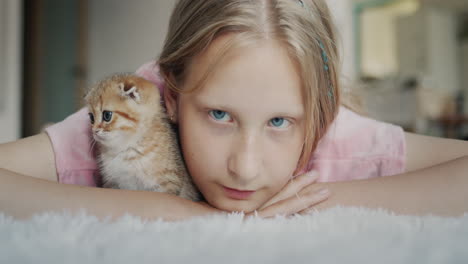 portrait of a child with a kitten looking at the camera