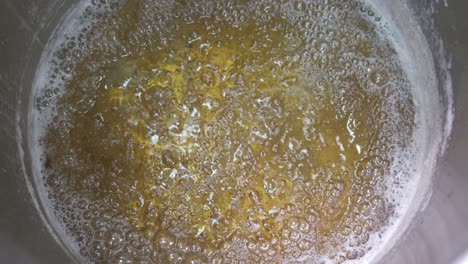 close-up of a pot of boiled honey at the factory as they prepare to sugar the almonds to make turkish delight