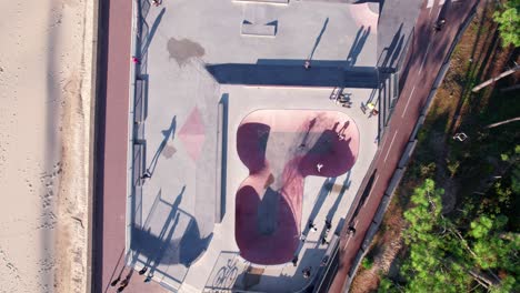 Skatepark-full-of-youngster-skateboarding,-aerial-top-down-shot