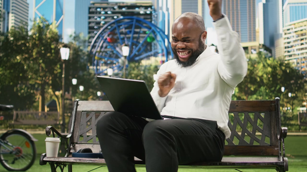Excited businessman celebrating success and positive results raising fists