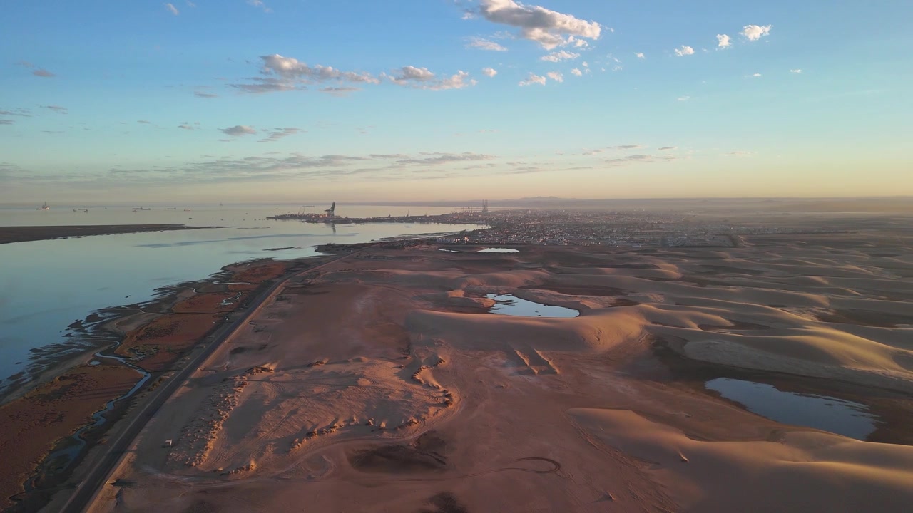 Luftfoto af ørkenkystområde med havn i det fjerne. Walvis Bay, Namibia.