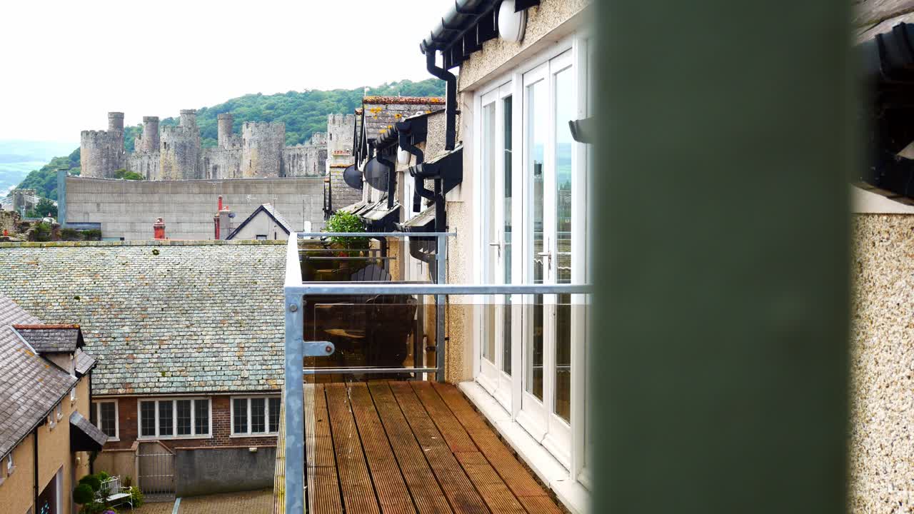 apartamento de lujo con balcón de cristal en conwy propiedad con balcón y vistas al castillo frente al mar por encima de los tejados dolly a la izquierda