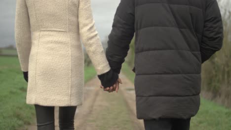 couple holding hands walking away