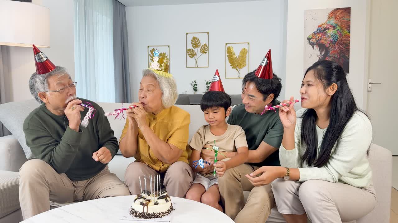 Four family members enjoy a joyful birthday celebration with cake, party hats, and bright lighting