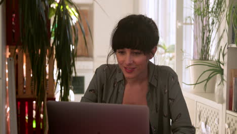 brunette woman video calling through computer at home