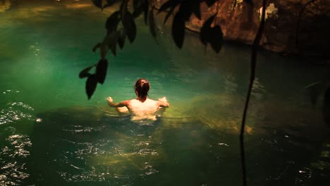 Un-Hombre-Que-Disfruta-De-Un-Momento-Relajante-Vadeando-En-Un-Estanque-En-El-Bosque,-Muestra-El-Concepto-De-Atención-Plena,-Salud-Mental-Y-Afrontamiento-Del-Estrés