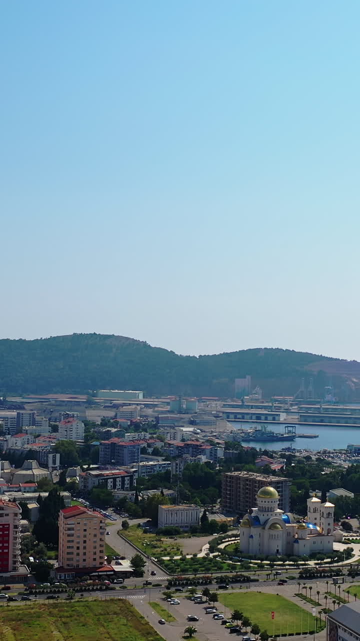 Modern resort city at the shore of Adriatic Sea. Drone footage above the cityscape and waterscape. Bar, Montenegro from aerial view. Vertical video