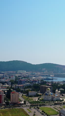 modern resort city at the shore of adriatic sea. drone footage above the cityscape and waterscape. bar, montenegro from aerial view. vertical video