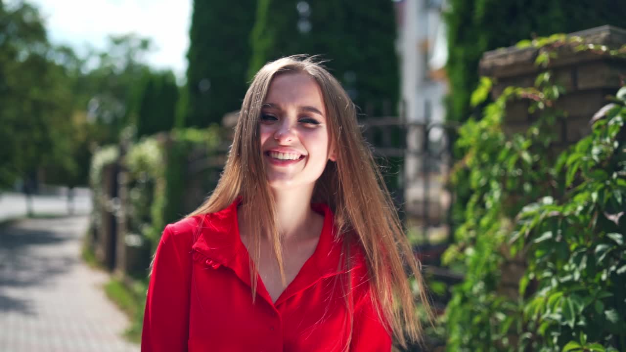 Woman smiling in urban background. Happy young woman smiling outdoors and walking on city street