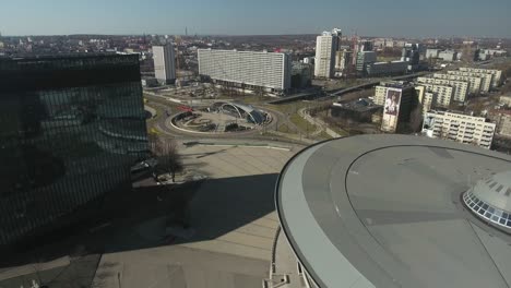 the center of a major city in central europe, featuring a building shaped like a flying saucer