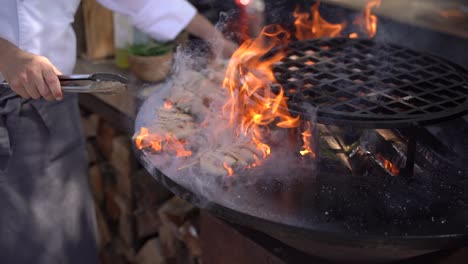 el chef hornea el calamar en pinzas de madera.