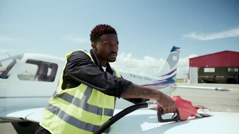 black ground technician refueling wing talk of small aircraft