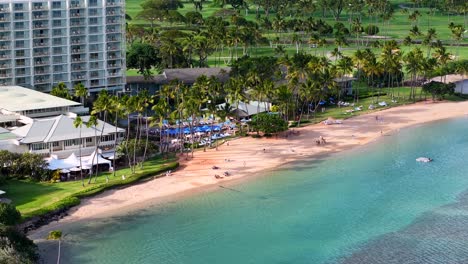 guests relax on the beach at a luxury resort and golf course in hawaii