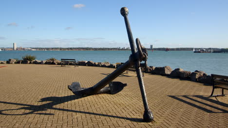 wide mid shot of an old anchor at hythe marina village with weston in background