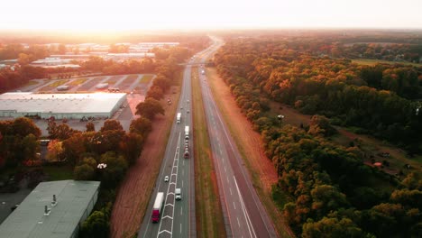 Vistas-Aéreas-Del-Atardecer-Mágico-De-Carga-Por-Carretera-Transportada-Por-Semirremolques-Y-Remolques-En-La-Interestatal-I-80-Elkhart-Indiana