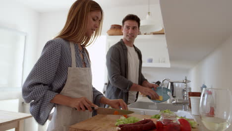 Pareja-De-Adultos-Jóvenes-Hablando-Mientras-Preparan-La-Comida-Y-Se-Lavan,-Filmada-En-R3d