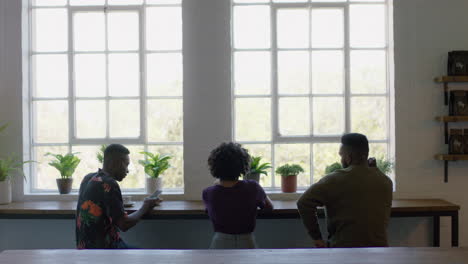 group of friends drinking coffee together in cafe talking having conversation enjoying socializing on lunch break in restaurant shop
