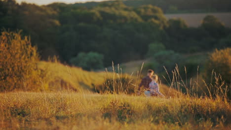 young couple walking toward sunset. young couple man and woman walking toward sunset