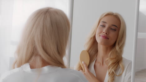mujer cepillándose el cabello delante de un espejo