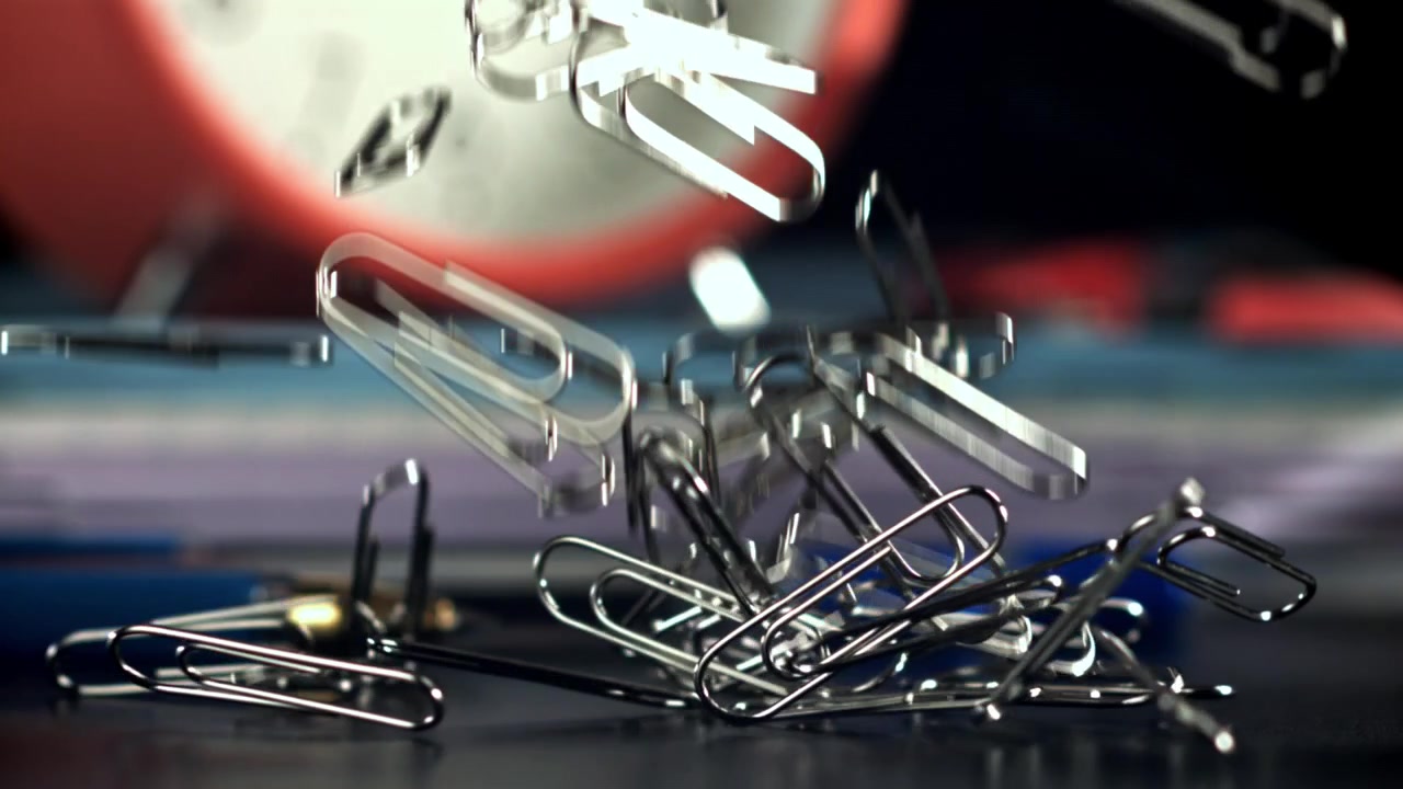 Silver Paper Clips Falling in Slow Motion on an Office Desk