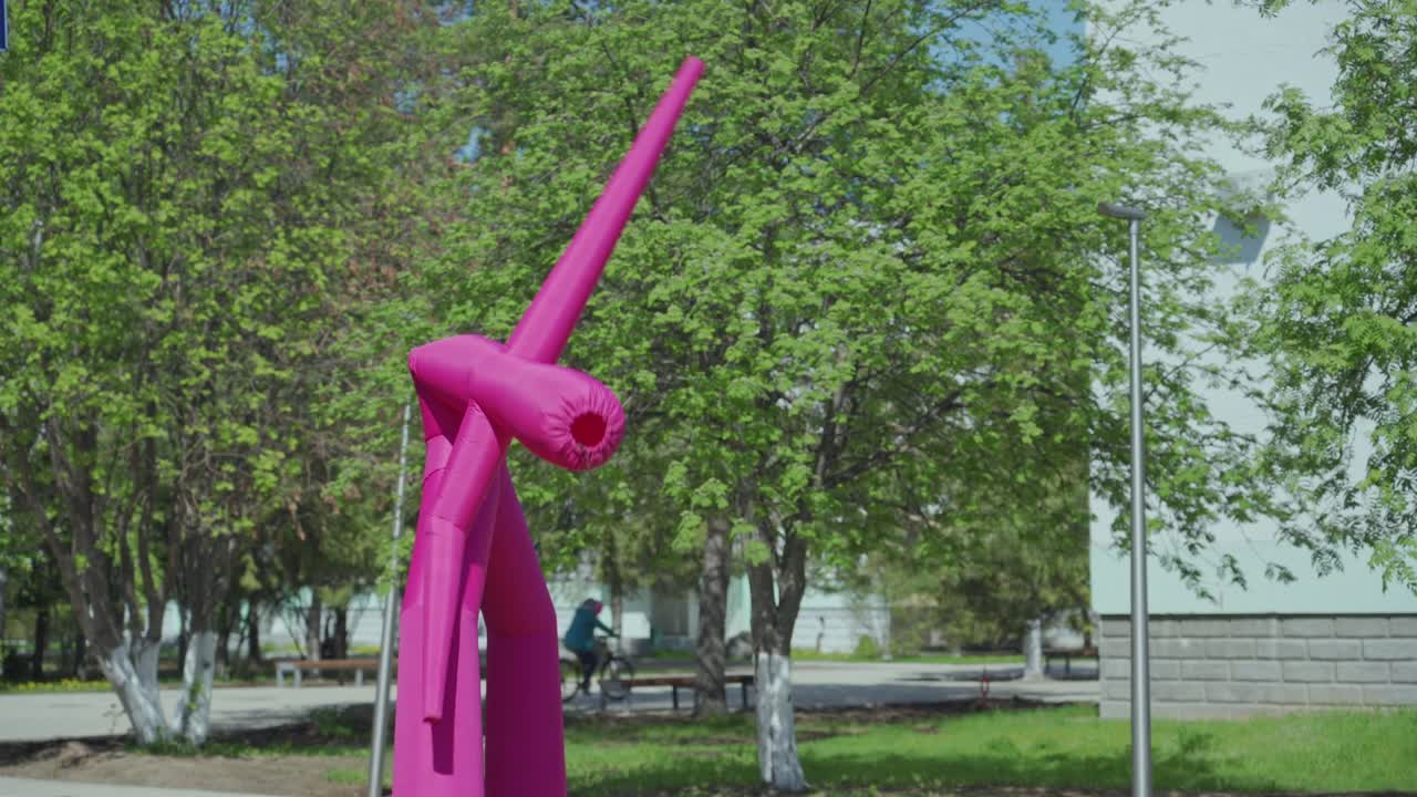 시내 거리에서 춤을 추는 광고를 위해 분홍색 부풀어 오르는 남자