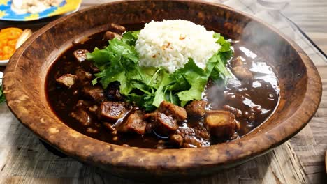 aromatic steam rising from a rustic wooden bowl filled with a savory pork dish, accompanied by fluffy white rice and fresh green herbs