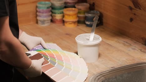 a worker applies a paint sample to a palette for color verification