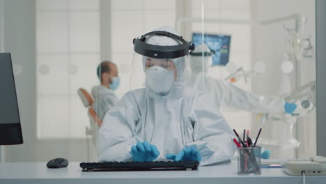 Stomatology-assistant-sitting-at-desk-using-computer