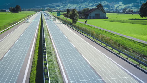 Lapso-De-Tiempo-De-Una-Autopista-Concurrida-Con-Líneas-De-Asistencia-De-Carril-Digital-A-Través-Del-Paisaje-De-Montaña-Verde