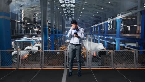 full body of an asian male professional worker standing with his smartphone at the center of the wind turbine factory, he is nodding his head with dissapionted