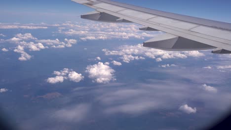 mirando desde la ventana del avión al ala y al cielo parcialmente nublado