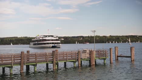 medium wide shot of a boat on a lake approaching a pier in the foreground