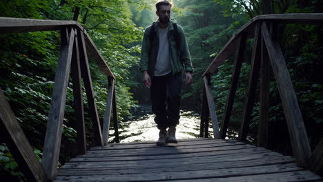 a man walking on a wooden bridge in a forest