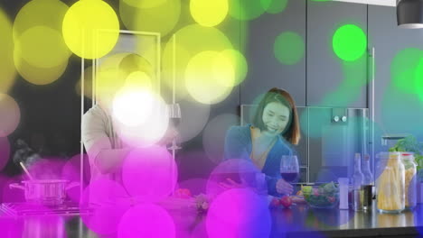 animación de luces bokeh coloridas sobre personas cocinando y bebiendo vino en la cocina
