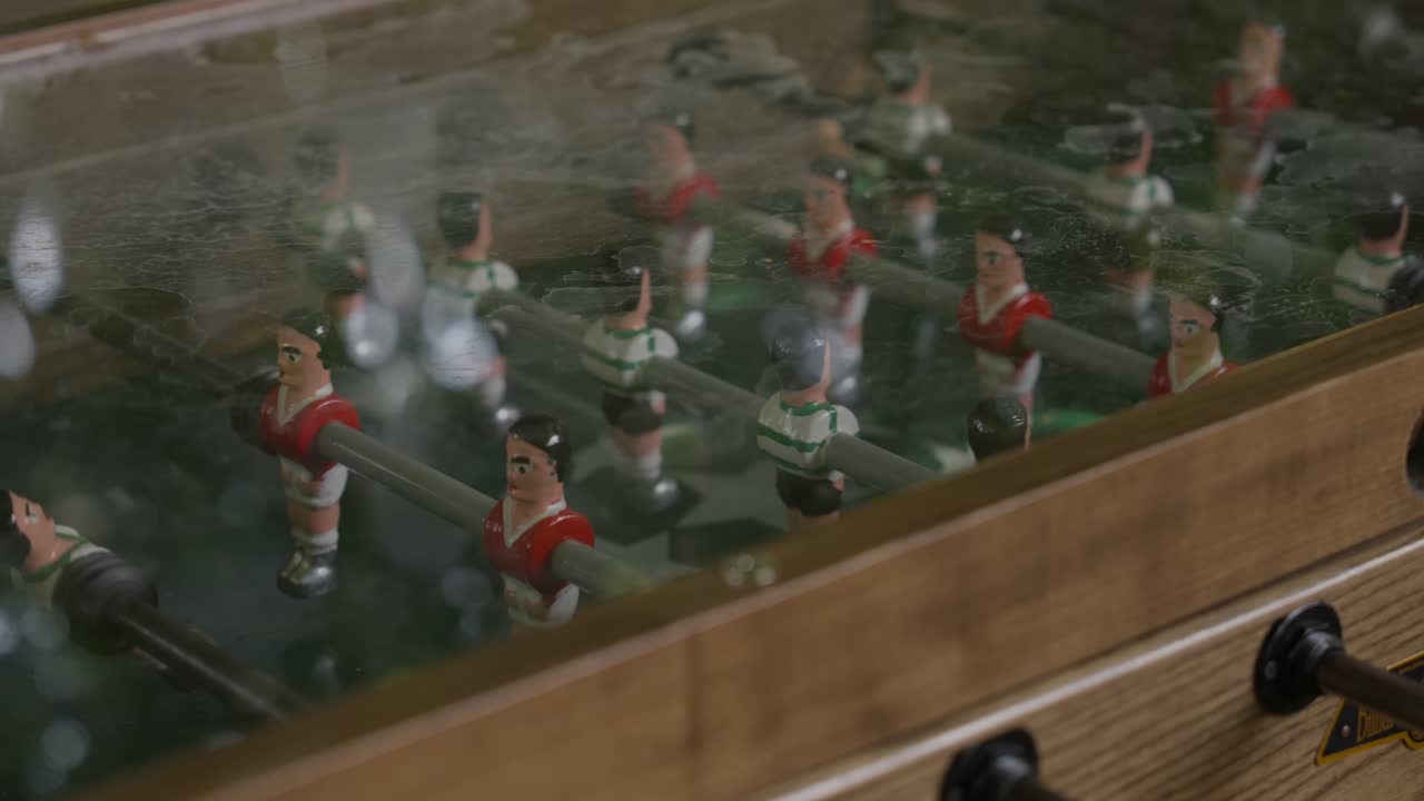 Close up of foosball table players seen through glass surface