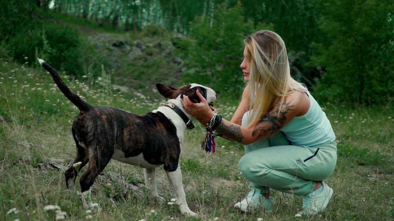 Woman and her Bull Terrier dog playing outdoors
