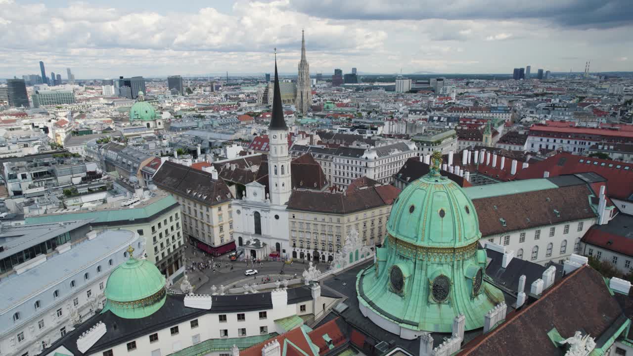 Aerial orbiting shot over iconic Michaelerplatz Square with Hofburg Palace and St. Michael Church, Vienna
