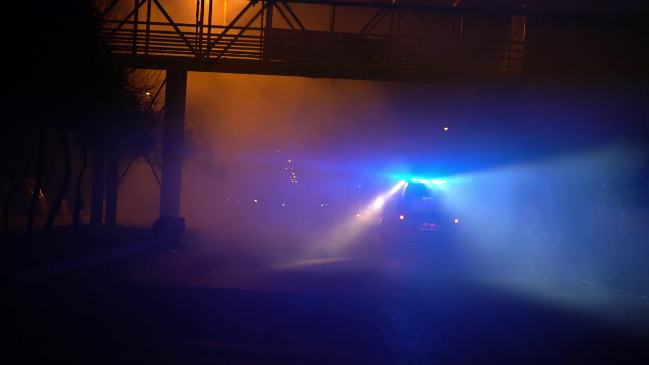 una luz de ambulancia parpadeante podía ser observada desde una corta distancia después de una escena caótica de una protesta en trípoli, líbano que hizo que el ambiente fuera humeante y brumoso