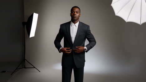 professional man in suit posing and checking watch in studio