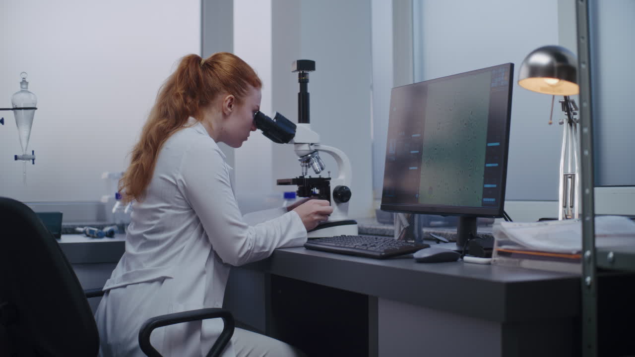 ученый, исследующий образец под микроскопом