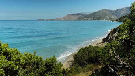 Malerische-Mediterrane-Ruhe:-Azurblaues-Meer,-Leerer-Schöner-Strand,-Von-Grünen-Hügeln-Aus-Gesehen-–-Ein-Ruhiges-Küstenparadies