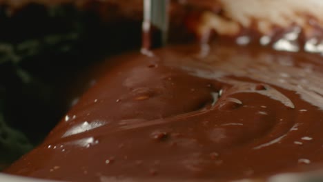 a spoon stirs melted chocolate