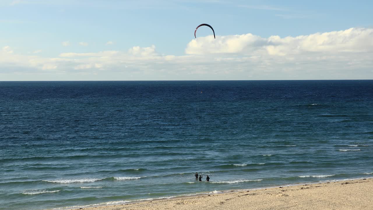 surfistas que realizan actividades marinas en la playa tropical de hayle en cornwall, inglaterra