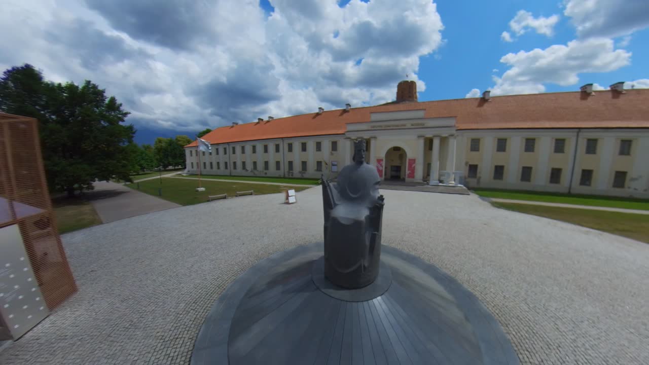 Exterior view of the National Museum of Lithuania and the Gediminas Statue on a sunny day