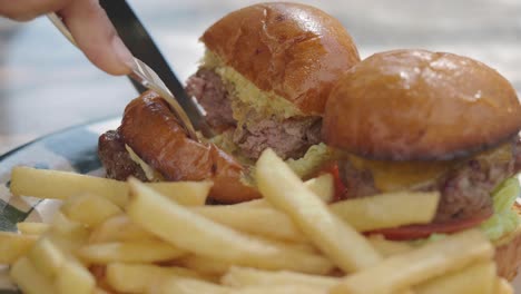 close-up of cutting a delicious slider burger with french fries