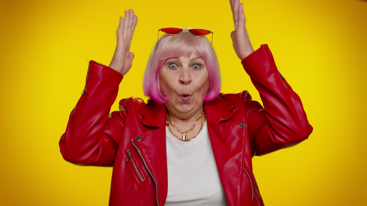 쾌활한 고령 여성이 어린아이처럼 놀고, 안전한 느낌으로 머리 위에 지붕을 짓고 있습니다.