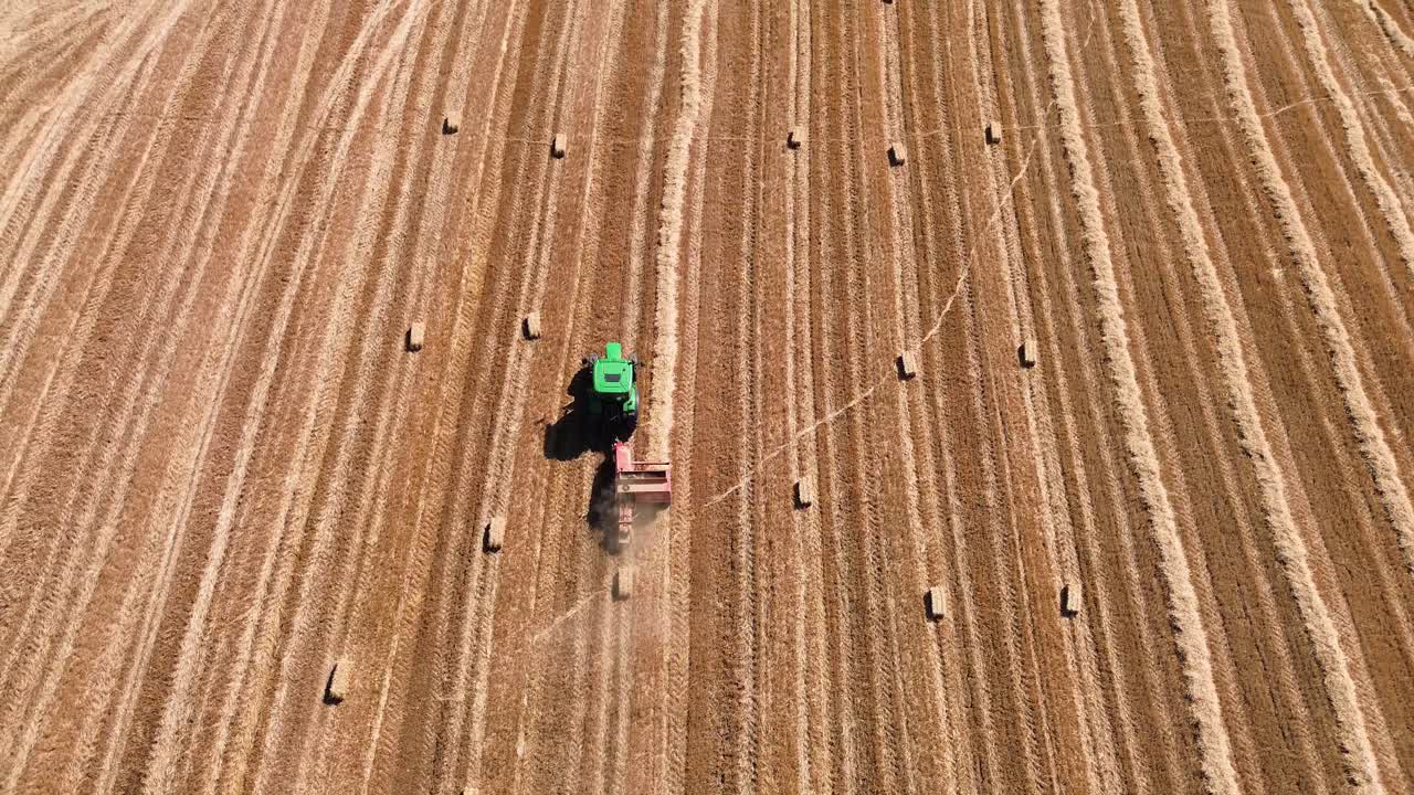 Hay baler tractor on the field compressing automatic farm machine agriculture rural, aerial drone